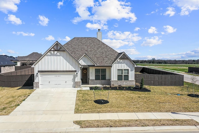 modern farmhouse style home with concrete driveway, board and batten siding, a front yard, and fence