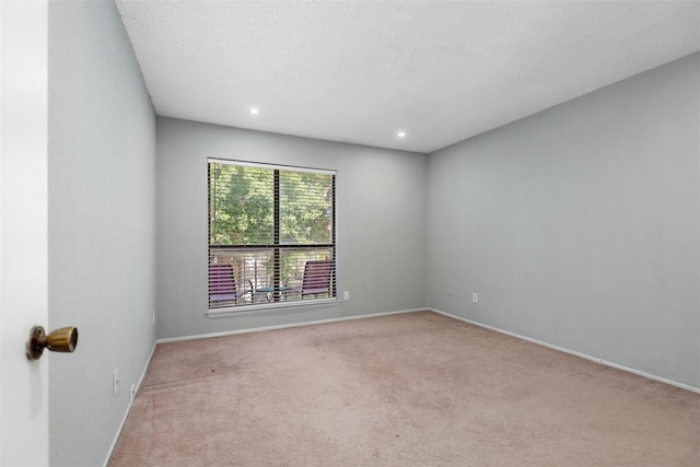 carpeted empty room featuring a textured ceiling, recessed lighting, and baseboards