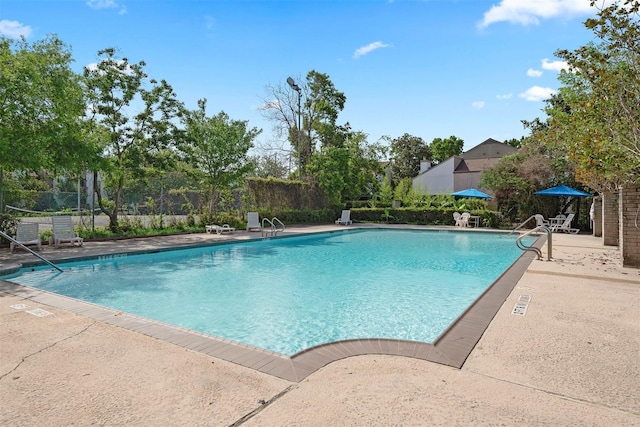 community pool featuring a patio and fence