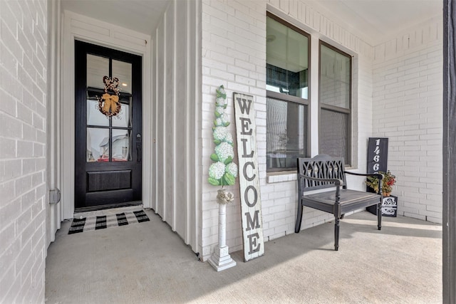 property entrance with brick siding and covered porch