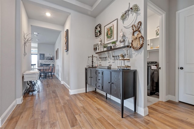 corridor featuring light wood-style flooring and baseboards