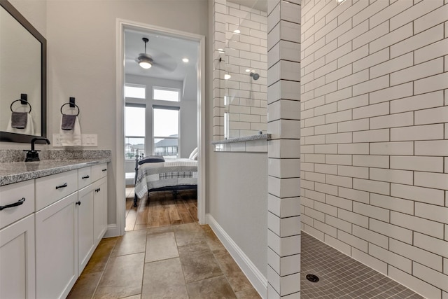 bathroom with baseboards, ensuite bathroom, walk in shower, and vanity