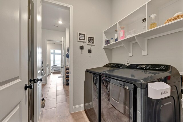 washroom featuring light tile patterned floors, laundry area, independent washer and dryer, and baseboards