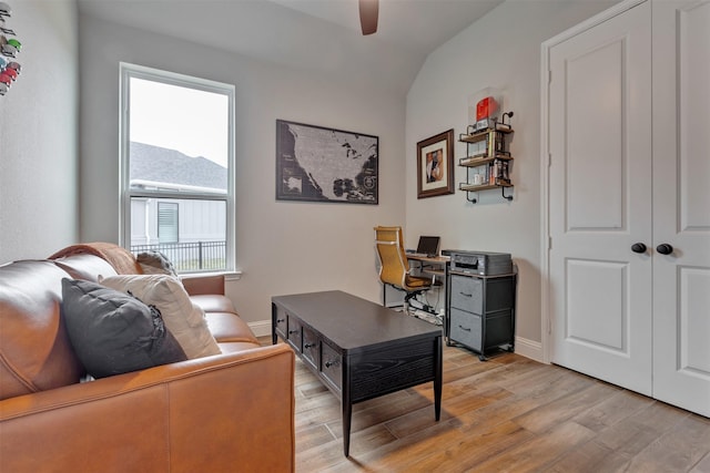 office featuring baseboards, a ceiling fan, and light wood-style floors