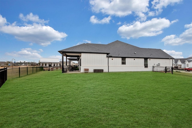 back of property featuring a patio area, a yard, a fenced backyard, and roof with shingles