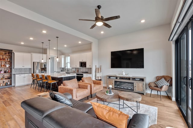 living area featuring recessed lighting, light wood-type flooring, baseboards, and a ceiling fan