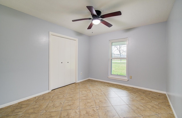 spare room with light tile patterned floors, ceiling fan, and baseboards