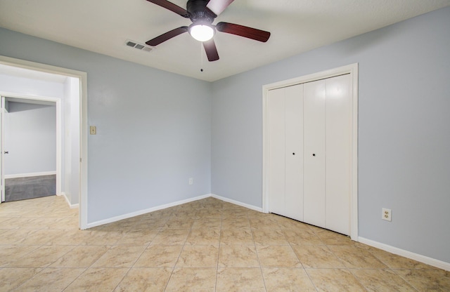 unfurnished bedroom with tile patterned flooring, baseboards, visible vents, and a closet