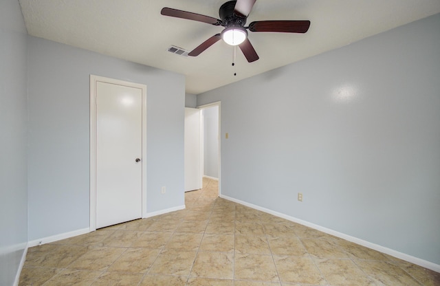 unfurnished bedroom with tile patterned flooring, visible vents, ceiling fan, and baseboards