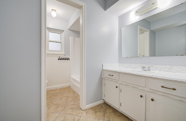 bathroom featuring a bathtub, a shower, vanity, baseboards, and tile patterned floors