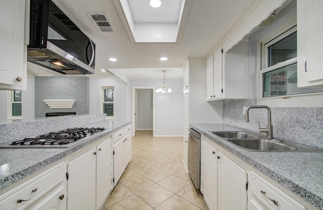 kitchen with appliances with stainless steel finishes, white cabinets, and a sink