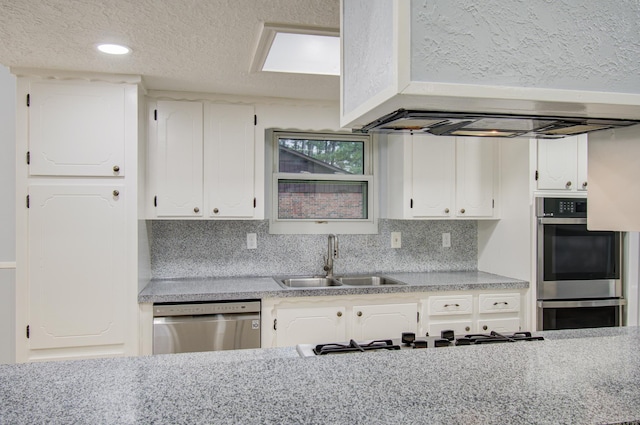 kitchen featuring appliances with stainless steel finishes, a sink, and white cabinets