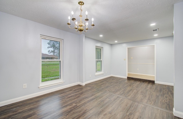 spare room with baseboards, wood finished floors, visible vents, and a healthy amount of sunlight