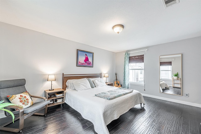 bedroom featuring dark wood-type flooring, visible vents, and baseboards