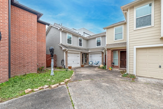 view of front of home with driveway, a garage, and brick siding