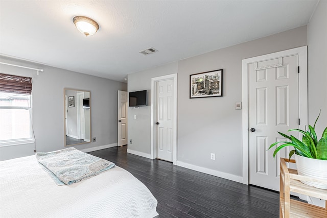 bedroom with dark wood-type flooring, visible vents, and baseboards