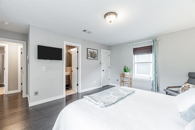 bedroom featuring dark wood-type flooring, visible vents, connected bathroom, and baseboards