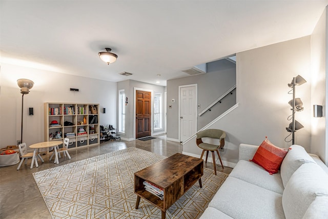 living area with visible vents, baseboards, and stairs