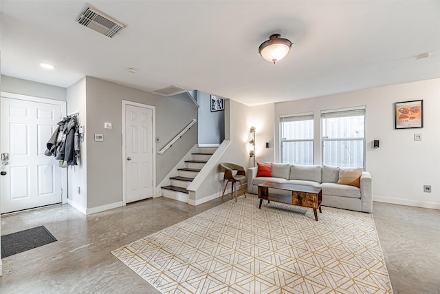 living room featuring stairs, finished concrete floors, visible vents, and baseboards