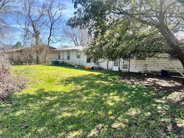 view of yard with central AC unit and fence