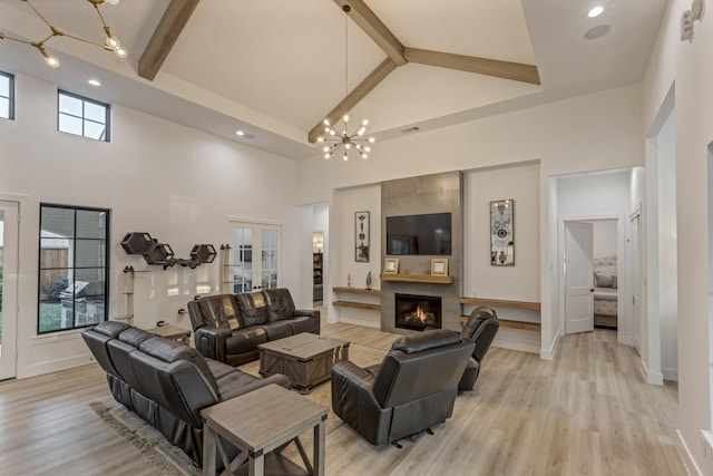 living room featuring beamed ceiling, a fireplace, a chandelier, and high vaulted ceiling