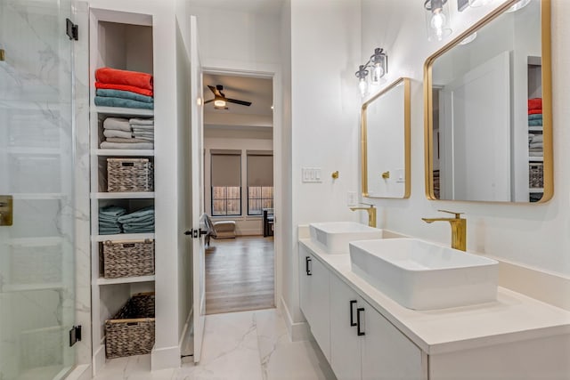 bathroom featuring double vanity, a stall shower, marble finish floor, and a sink