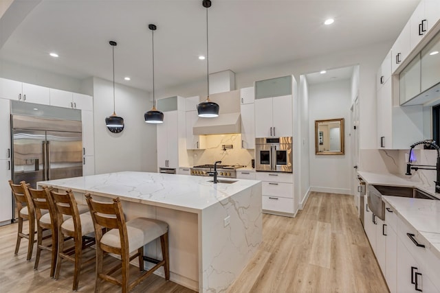 1522 Maux Dr, Houston, TX 77043 - kitchen with a sink, light wood-type flooring, a large island, appliances with stainless steel finishes, and decorative backsplash
