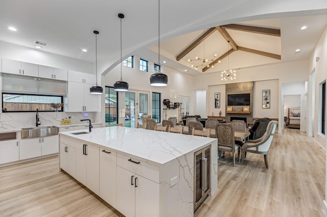 kitchen featuring a sink, visible vents, beverage cooler, and decorative backsplash