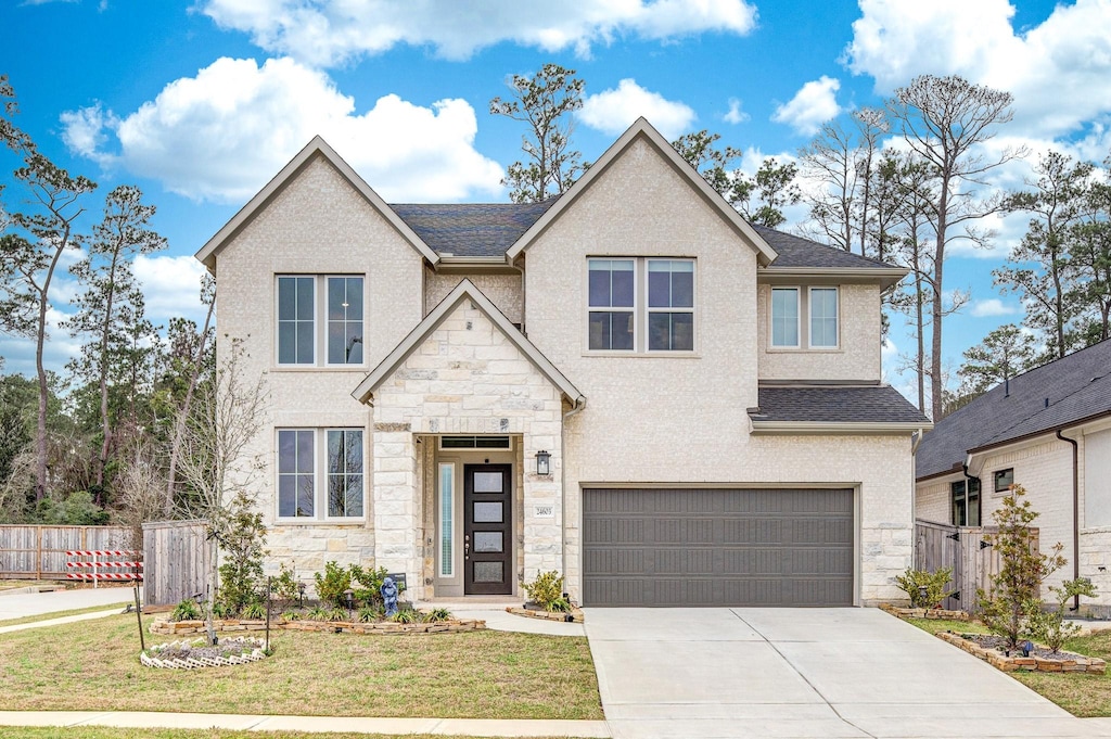 view of front of house with driveway, a front lawn, an attached garage, and fence