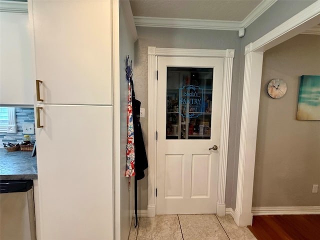 interior space featuring ornamental molding, baseboards, and light tile patterned floors