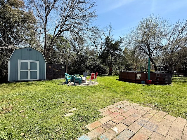 view of yard featuring an outdoor fire pit, a patio area, an outdoor structure, and a shed