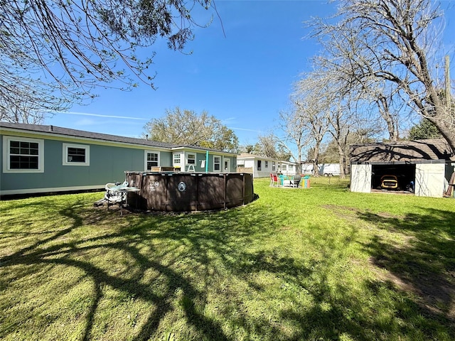 view of yard with an outdoor pool, an outdoor structure, and a storage unit