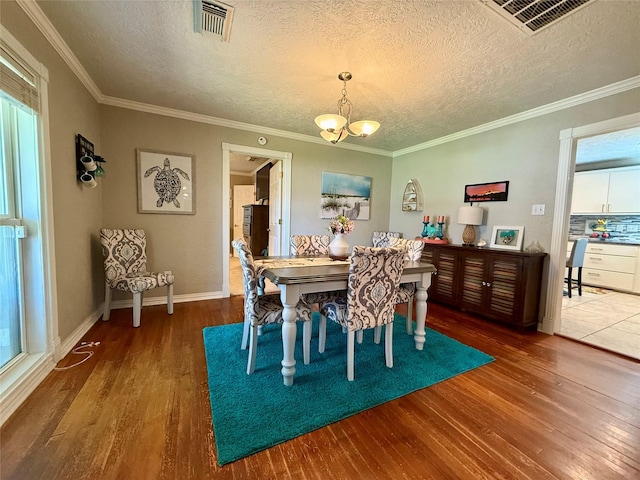 dining space featuring a wealth of natural light, visible vents, and wood finished floors