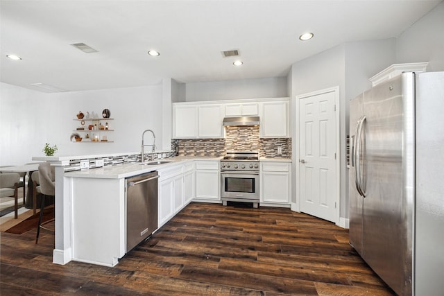 kitchen with visible vents, a peninsula, a sink, under cabinet range hood, and appliances with stainless steel finishes