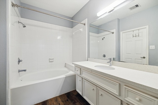 bathroom featuring vanity, wood finished floors, visible vents, and shower / bath combination