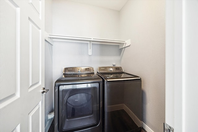 clothes washing area featuring laundry area and washer and clothes dryer