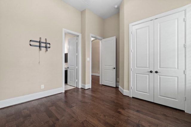 unfurnished bedroom featuring dark wood-style floors, a closet, and baseboards