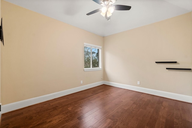 spare room featuring ceiling fan, baseboards, and dark wood-type flooring