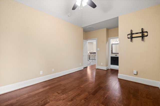 interior space with visible vents, dark wood finished floors, a ceiling fan, and baseboards