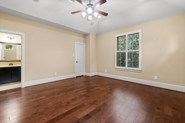 unfurnished room featuring baseboards, dark wood finished floors, a ceiling fan, lofted ceiling, and a sink