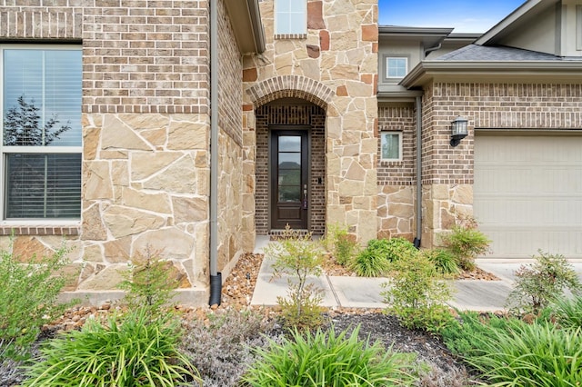 property entrance with a garage, stone siding, and brick siding