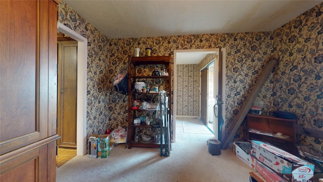 interior space with a textured ceiling, light colored carpet, and wallpapered walls