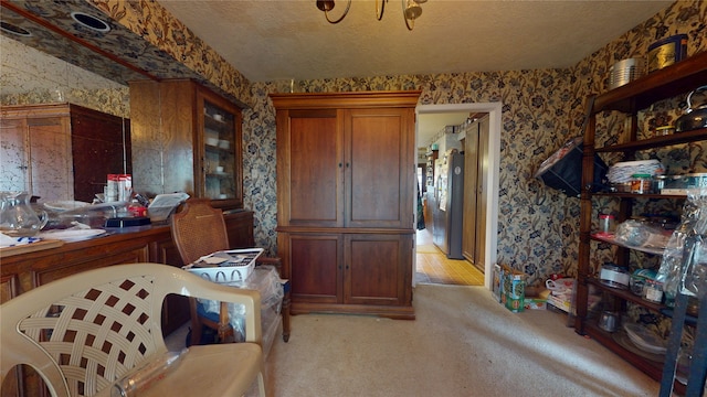 interior space featuring a textured ceiling, light colored carpet, and wallpapered walls