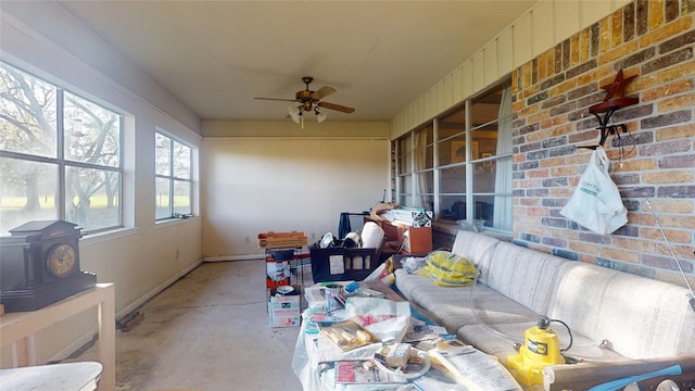 sunroom / solarium featuring ceiling fan and a wood stove