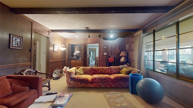 living area with a textured ceiling, beamed ceiling, carpet, and visible vents