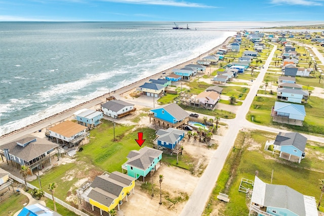 aerial view featuring a view of the beach, a water view, and a residential view