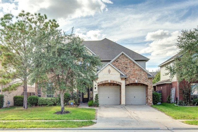 view of front of home featuring a shingled roof, a front lawn, concrete driveway, and brick siding