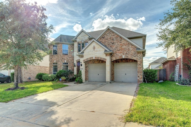 view of front of property with driveway, brick siding, an attached garage, and a front yard