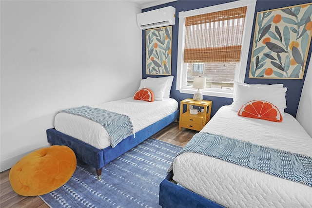 bedroom featuring an AC wall unit and wood finished floors