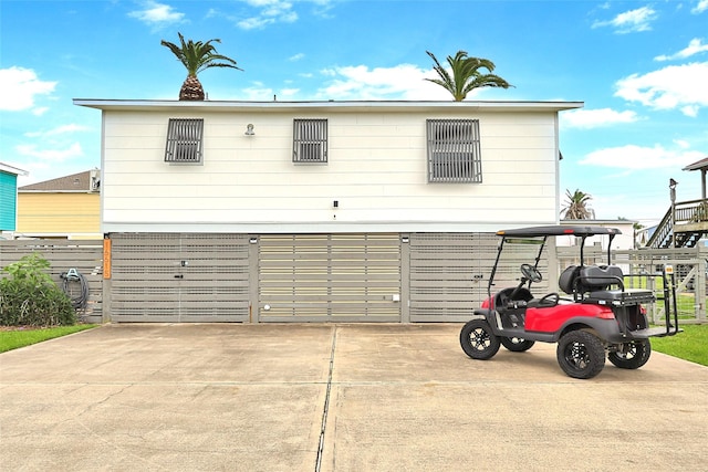 view of front facade featuring a garage, concrete driveway, fence, and a gate